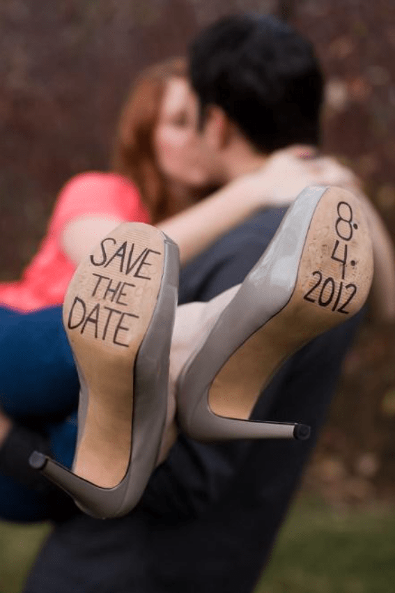 Couple kissing while soles of shoes show save the date